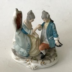 Escultura decorativa de porcelana européia (sem marca) com imagem de antigo casal em cena galante, aprox. 13 x 11,5 x 9,5 cm - Século XIX