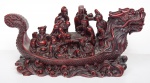 Escultura chinesa em material sintético imitando laca representando "Barcaça em forma de  dragão" portando os "Sete sábios e deusa Kuan yim". Med.: 13 x 16 cm.