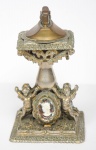 COLECIONISMO - Curioso isqueiro de mesa em metal espessurado dourado e prateado representando "Anjos" com camafeus em cristal e figuras femininas. Med.: 15 cm.