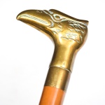 COLECIONISMO - Bengala com haste em madeira nobre e castão em metal dourado representando "cabeça de águia". Med.: 98 cm.