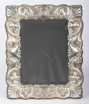 PRATA - Lindíssimo espelho de mesa em cristal bisotado com moldura barroca em prata italiana 925 mls, parte posterior  em mogno, apresenta selo da galeria "Gallo Milan" . Med.: 34 x 29 cm.