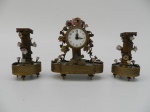 Garniture em miniatura, de bronze e porcelana. Apresenta pequenos danos. altura do relógio 15cm