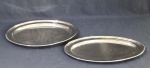 Duas travessas ovais de metal espessurado a prata. Medindo 51 x 31 cm e 51 x 40 cm. (No estado).
