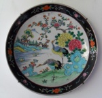 Medalhão de porcelana policromada, decorado com flamingos e flores. Med. 37 cm diam. China, séc. XIX.