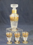 Conjunto de licoreira e 3 taças de cristal translucido com rica decoração em dourado, tampa circular lapidada.Mede 27 cm altura (licoreira) e 10,5 cm altura (taças).
