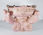 Centro de mesa em porcelana europeia na tonalidade rosa sustentado por Nereides. Med. 30 x 26 cm.