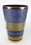 Vaso em vidro texturizado, com faixas douradas em vidro bordô escuro. Med. 24 x 17 cm.