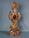 Relicário dourado no estilo rococó com imagem do Divino Espírito Santo. Mede 78 cm de altura. 