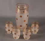 Conjunto em vidro composto de jarra coqueteleira e quatro copinhos. Mede a jarra 20cm e o copinho 8cm de altura.