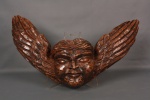 Cabeça de anjo entalhada na madeira. Mede 68cm de largura x 45cm de altura.