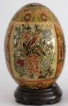 Ovo em faiança, estilo satsuma, com ricos detalhes na pintura com peanha de madeira - Altura c/ peanha: 14 cm