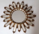 Belíssimo espelho dourado em resina de alta qualidade com formato de sol, seus raios decorativos contém espelho e volutas, ideal para dar um toque elegante e moderno para o ambiente - Diâmetro: 48 cm