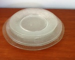 Seis pratos em vidro - Diâmetro: 24,5 cm ,um pratos, 27 cm dois pratos e três com 20 cm. - Lote com um  prato bicado.