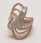 Exuberante anel em ouro amarelo e branco, adornado com diamantes redondos e baguetes, seguindo sinuosas curvas concebidas pelo design joalheiro. Aproximadamente 5.50 CTS. Aro  18.