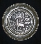 Prato circular decorativo de liga metálica  apresentando cena rural com cabras em relevo, 15,5 cm de diâmetro
