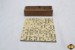 Antigo jogo de dominó com as pedras em baquelite bicolor e caixa de madeira. Uma das peças está quebrada ao meio, no estado.