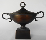 Peça em bronze clássico representando antigo troféu, medindo: 22 cm de altura x 28 cm.