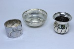 Três peças em prata contrastada sendo porta guardanapos em prata alemã, vaso em prata 925 ml contrastada e cesta em prata alemã. Peso: 81 g.