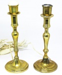 Par de castiçais em metal pesado, dourado, coluna torneada e anelada. Peças adaptadas para abajur. Alt.: 25 cm.