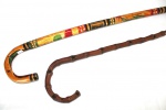 Duas bengalas em madeira sendo uma imitando bambu e outra esculpida e esmaltada, castão em arco. Comprimento: 90 cm e 89 cm.