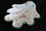 Gracioso centro de mesa no feitio de concha em porcelana húngara, manufatura "Herend". Peça esmaltada com flores e friso em tom verde. Medidas: 23 X 22 cm.