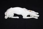 Figura em porcelana europeia branca representando "Cachorro". Pata colada. Comprimento: 21 cm.