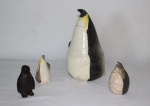 Quatro esculturas, sendo 3 esculpidas em cerâmica policromada e 1 em metal, representando "Pinguins". Alt. da maior: 27cm.  (Um pinguim com bicado).