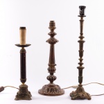 Lote constando três bases para abajur sendo duas em bronze e uma em madeira. Med.: 51 cm, 43 cm e 39 cm.