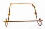 Elegante toalheiro confeccionado em metal dourado tubular recurvo, acabamentos em forma de pinha. Med.: 36 x 42 cm.