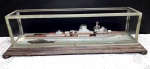 COLECIONISMO - Decorativo navio de guerra em madeira emoldurado por vitrine de metal e vidro sobre base de madeira de lei. Mede 17 x 16 x 57. OBS: NO ESTADO. Faltam vidros da vitrine e itens do próprio navio.