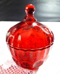 Púcaro em vidro de tom vermelho decorado por bolhas em relevo inverso medindo 14,5 cm de altura.