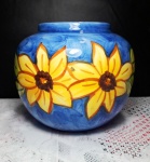 Vaso floreira em cerâmica vitrificada em belo tom azul decorado por flores amarelas. Mede 15 cm de altura. 