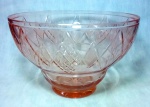 CRISTAL - Saladeira em cristal de tom rosé ricamente lapidada a mão com recortes geométricos medindo 14 cm de altura por 21 cm de diâmetro.