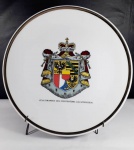 Belo prato decorativo em porcelana decorado pela bandeira de Liechtenstein e filetação dourada em sua borda. Mede 24 cm de diâmetro.