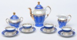 Conjunto para café em porcelana na cor azul e furta-cor e detalhes em fio de ouro. Acompanha um bule para café, uma leiteira, um açucareiro e quatro xícaras com seus respectivos pires.