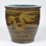 Belíssimo Cachepot, revestido em cerâmica com figuras de dragões em relevo, na tonalidade do marrom. Med.: 50x50 cm.