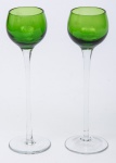 Par de cálices para licor em vidro artístico sendo a taça na cor verde e base alta em vidro translucido. Med: 0,18 x 0,05 cm.