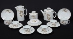 Lindo conjunto em porcelana para chá, na cor branca, decorada com flores e borda a fio de prata, composto de:  Seis xícaras para chá com seus respectivos pires, um bule para chá, uma leiteira, um açucareiro, uma manteigueira. Total de 10 peças.