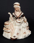 Estatueta em cerâmica vitrificada nas cores bege e marrom predominantes representando Dama camponesa. Med.: 28 x 14 cm.