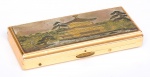 Cigarreira oriental em metal dourado, com caixa de música, apresentando decoração de "Paisagem" à cinzel na tampa. Funcionando. Med.: 11,5 x 5,5 cm.
