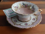 Xícara de chá em porcelana decorada com pintura manual e  e frisos dourados.