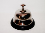 Campainha de metal tipo sineta com acionamento por botão superior com a base em formato arredondo na cor preto. Peça sem uso e na caixa original