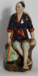 Escultura em porcelana/biscuit pintado à mão com marca em sua base, ricamente policromado representando figura oriental. Medida: 21 cm de altura