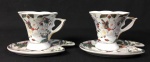 Par de xícaras de chá em porcelana esmaltada  com decoração policromada floral acompanham pires. Medida: 7 cm alt; 12 cm de comprimento(pires)