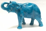 Escultura em cerâmica/faiança vitrificada na cor azul turquesa representando figura de elefante. Medida: 20 cm x 14 cm