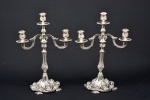 Par de candelabros em metal espessurado à prata europeu decorado por conchas e volutas para três velas. Medida: 39 cm de altura x 28 cm