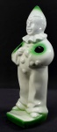Escultura em porcelana representando palhaço porta-escova com pintura em tom verde e branco. Medida: 19 cm de altura