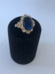 CÓPIA DE JOIA- Belíssimo anel em metal dourado, galeria central composta por lindíssima pedra na cor azul turquesa. Aro. 22