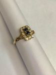 Exuberante anel em ouro 18k, ricamente cravejado por brilhantes, composto por duas safiras azuis central. Aro. 16