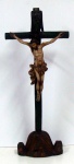 Imagem de Cristo Crucificado de origem pernambucana século XVIII, esculpido em madeira policromada medindo 37cm de altura por 34cm de comprimento. A cruz tem 91cm de altura esculpida em tronco nodoso. Resplendor em prata 10 dinheiros